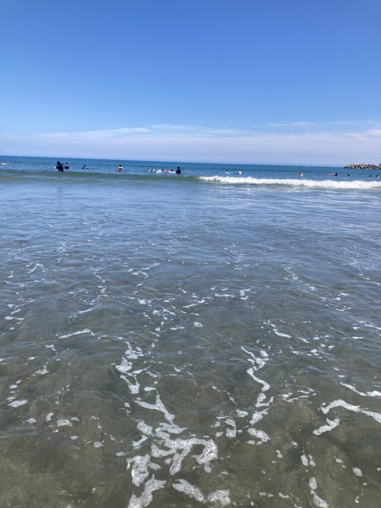 前原海水浴場の浅瀬。多くの人が海水浴を楽しんでいる。