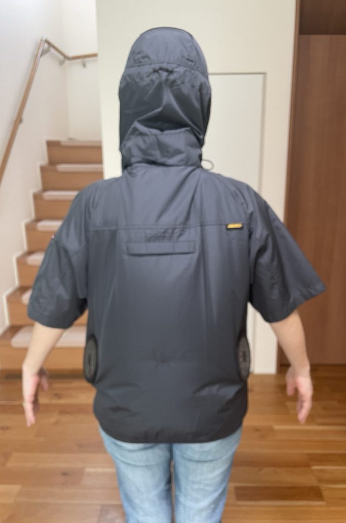 空調服を着ている女性の背部からの姿。風量9V